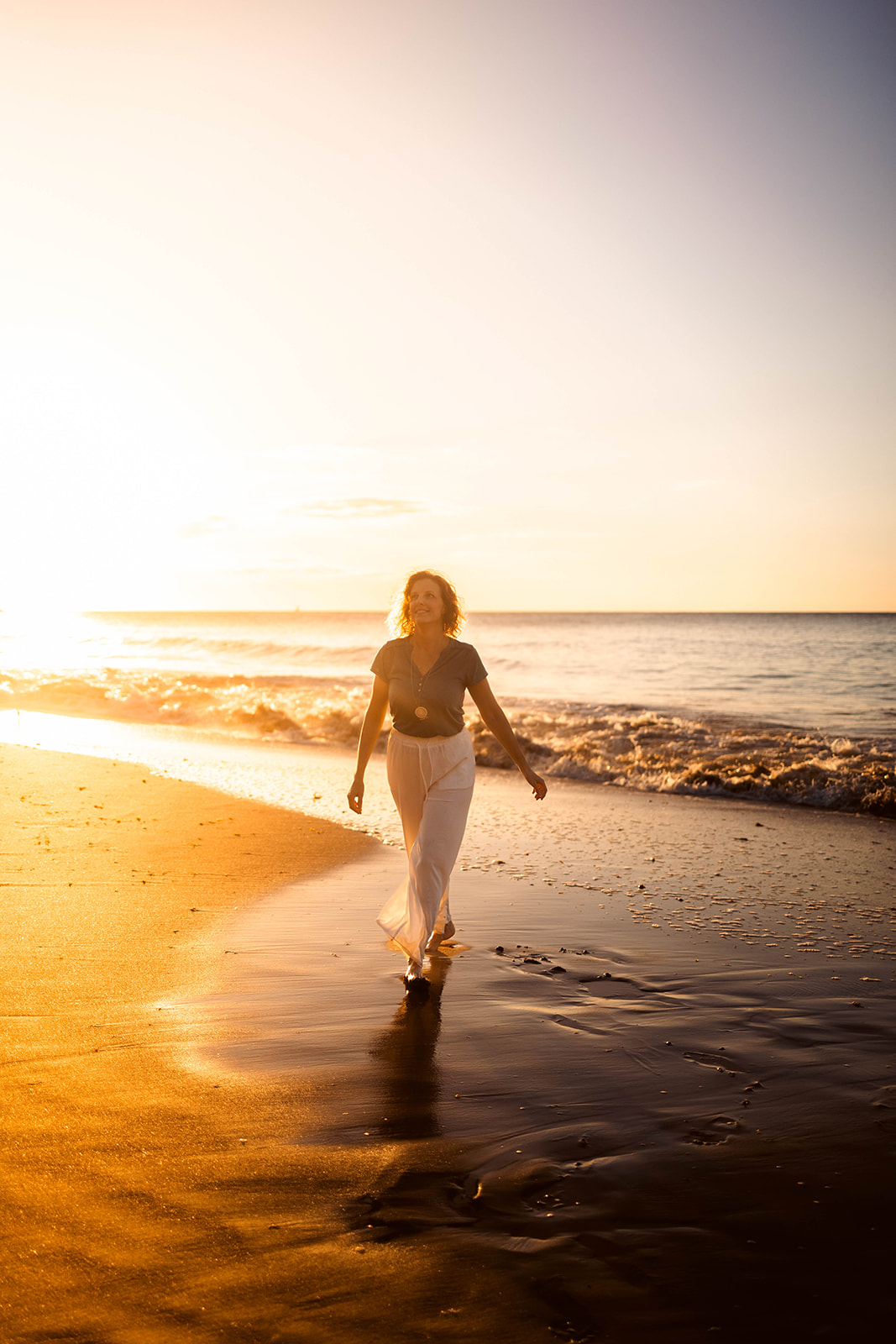 Aurélie Hernanz marchant au bord de l'eau au coucher du soleil